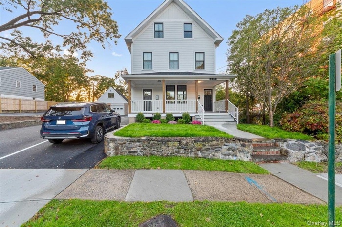 View of front of home featuring covered porch, a front yard, and board and batten siding