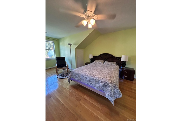 Bedroom featuring wood finished floors, ceiling fan, and vaulted ceiling