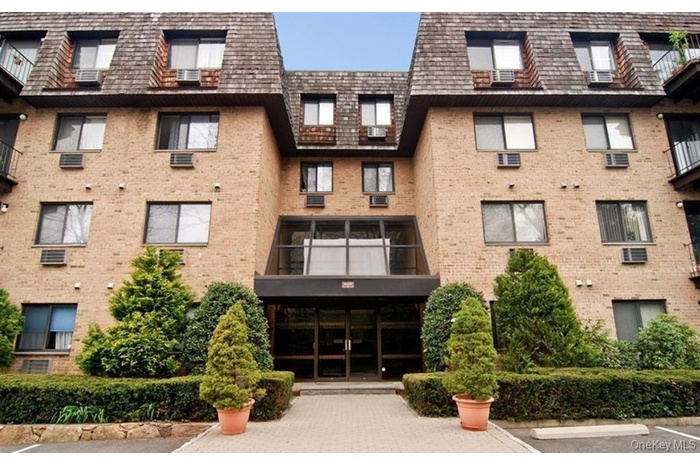 View of apartment building / complex with uncovered parking