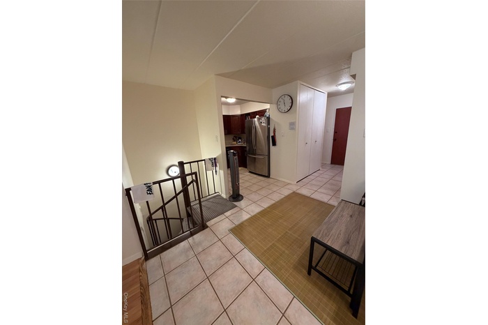 Hall with light tile patterned floors and baseboards