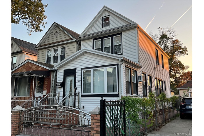 View of front of house with a fenced front yard and a gate
