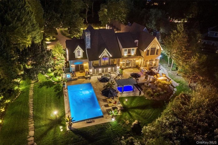 Pool at twilight featuring a patio area, an outdoor living space with a fire pit, outdoor dining space, and an outdoor pool