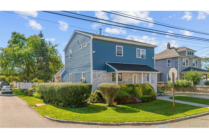 View of front of home featuring stone siding and covered porch