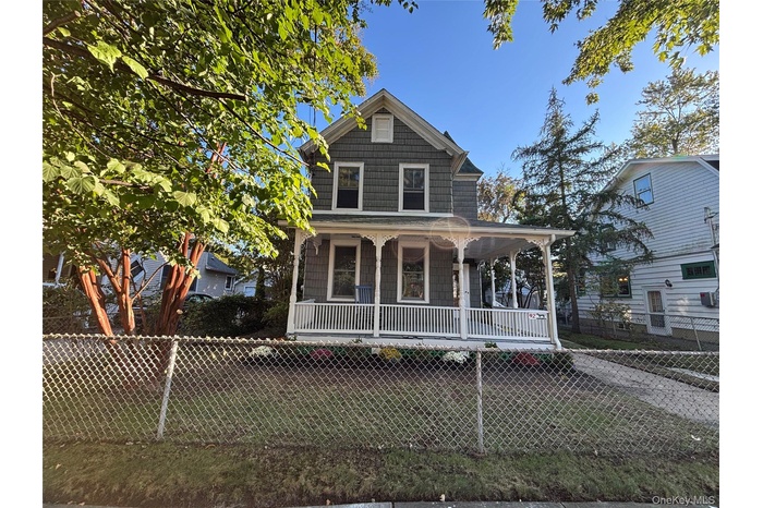 View of front of property with a porch and a fenced front yard