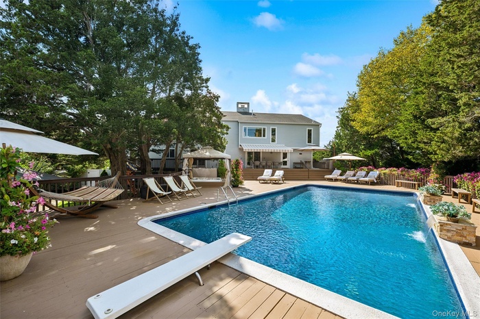 View of pool featuring a patio area, a diving board, a gazebo, and a wooden deck