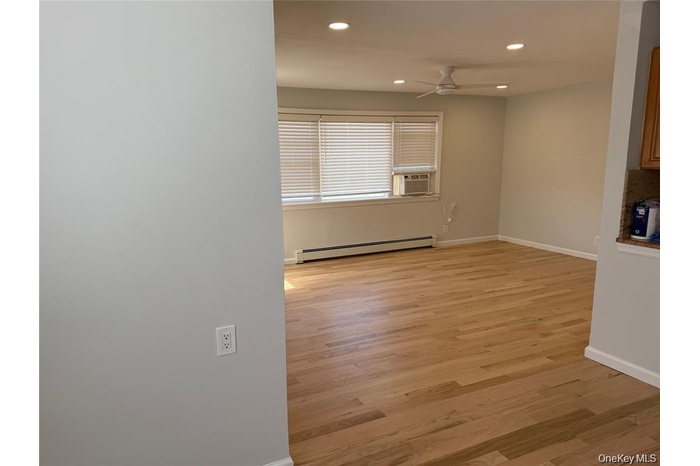 Unfurnished room with recessed lighting, a baseboard radiator, light wood-style floors, ceiling fan, and cooling unit