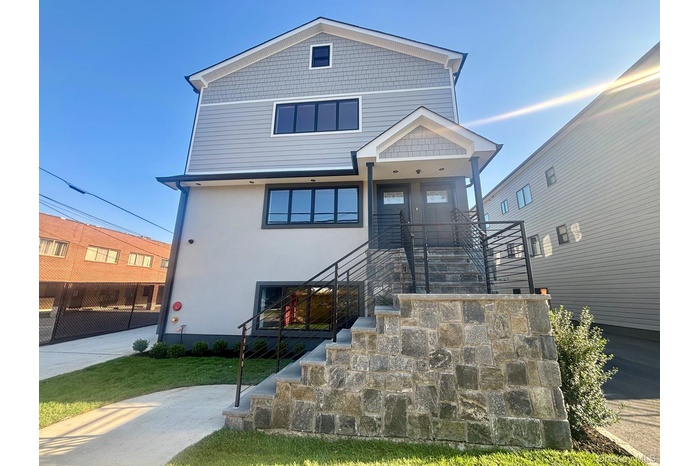 View of front facade with stairway and stucco siding