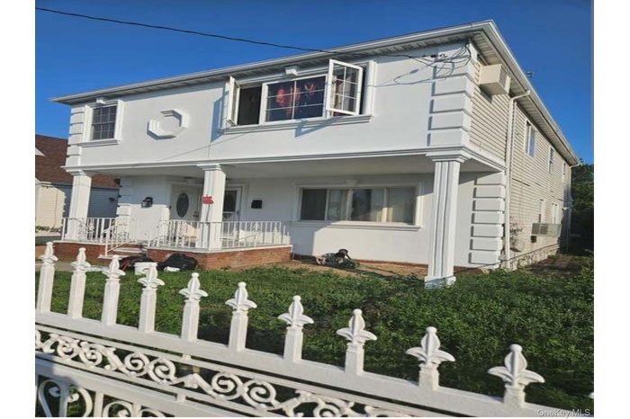 View of front facade with a porch and stucco siding