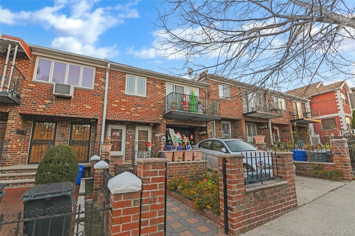 View of front of home with brick siding, a balcony, and a patio area
