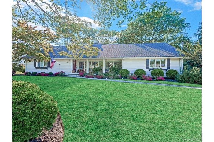 Ranch-style home featuring a front yard, a chimney, and roof with shingles