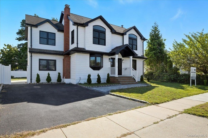 View of front of property featuring a chimney and roof with shingles