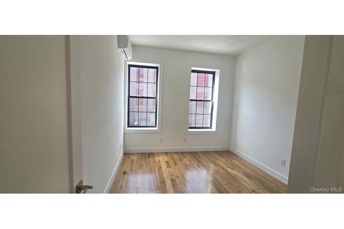 Spare room with light wood-style floors and a wall unit AC