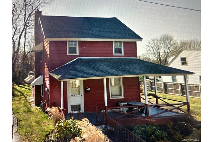 View of front of house with a shingled roof and a porch