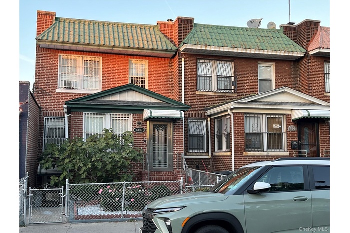 View of front of home featuring a gate and brick siding