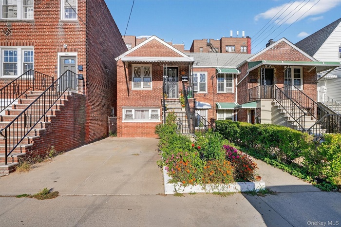View of front of house with stairs and brick siding
