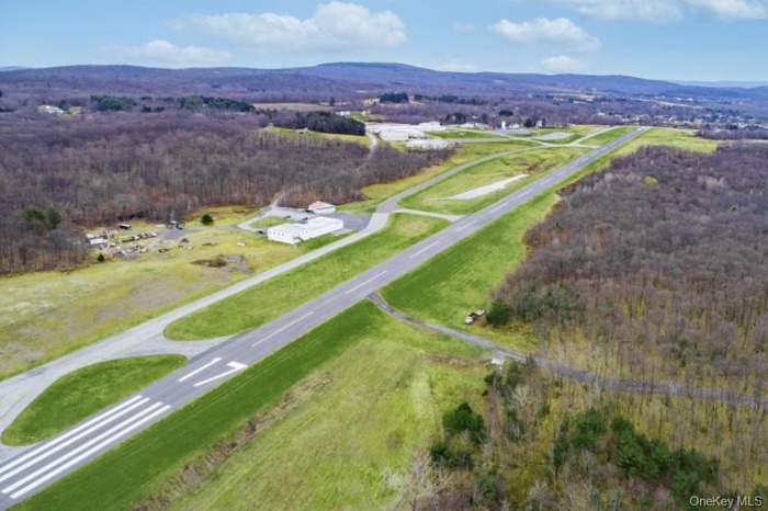 Aerial view of runways and taxiways with hangars to the left.