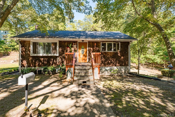 View of front facade featuring covered porch and a shingled roof