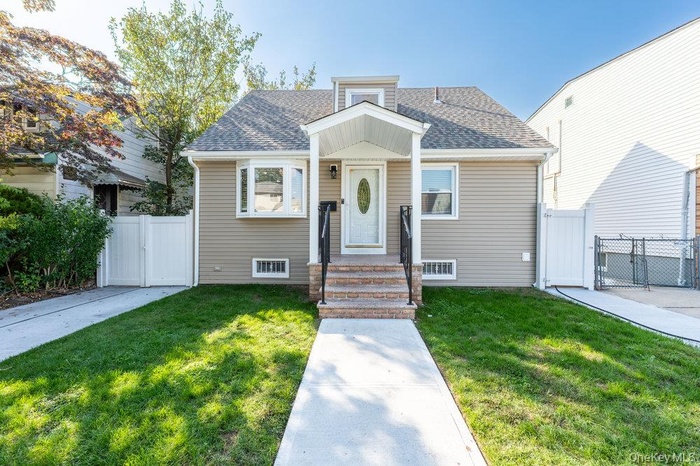 Bungalow-style home featuring a gate and roof with shingles