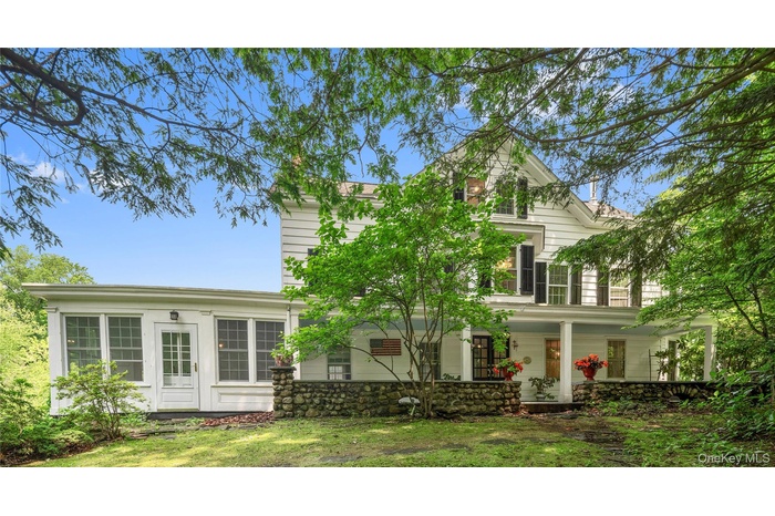 Rear view of house with covered porch and a yard
