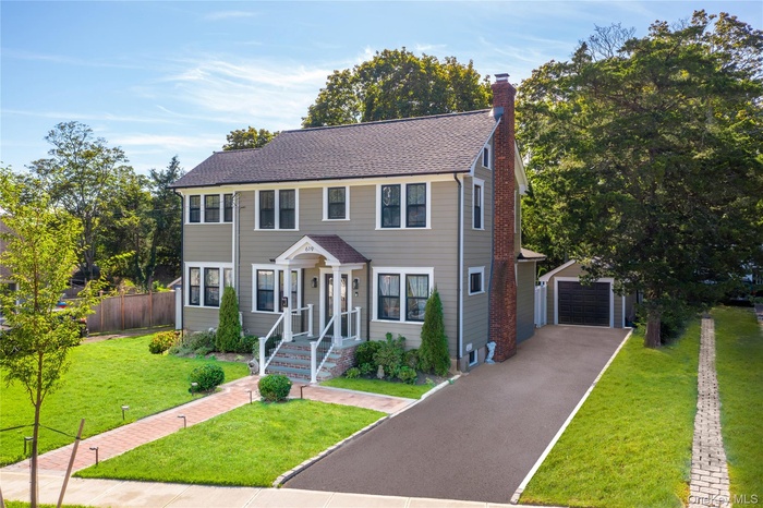 Farm House featuring an outdoor structure, a chimney, a garage, asphalt driveway, and roof with shingles