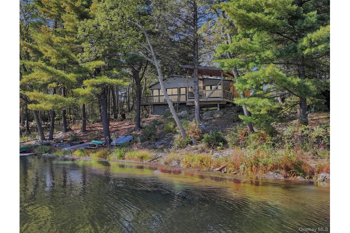 Back of property with a deck with water view