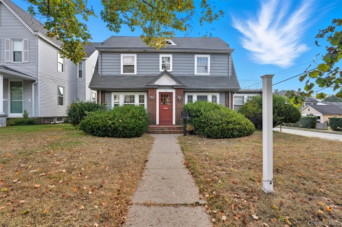 View of front of house featuring a front yard and brick siding