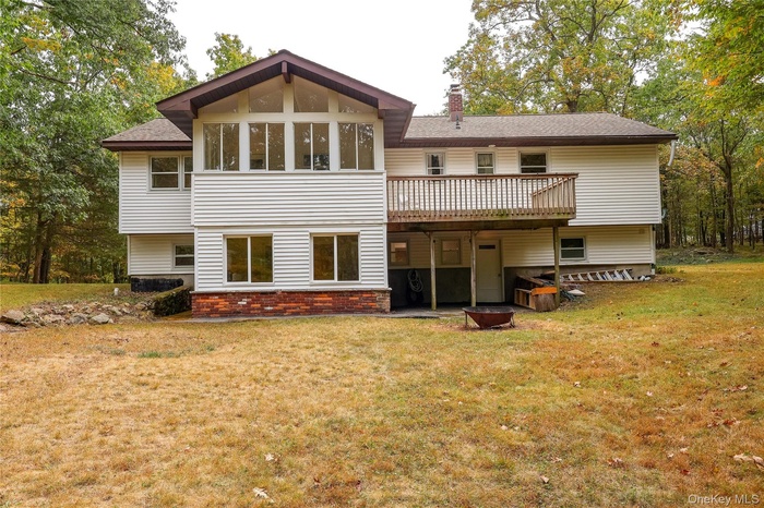 Back of property featuring a patio, a yard, a chimney, and brick siding