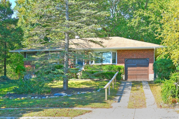 Single story home with brick siding and a front lawn
