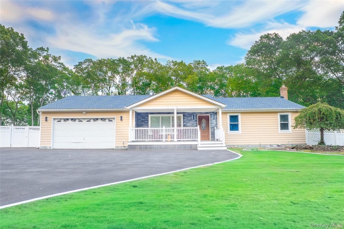 Single story home with covered porch, an attached garage, driveway, a chimney, and roof with shingles