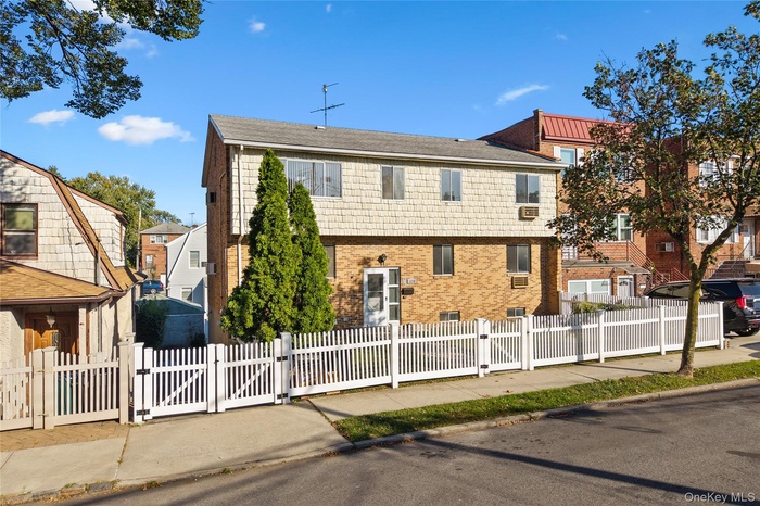 View of front of property featuring a gate, a fenced front yard, and brick siding