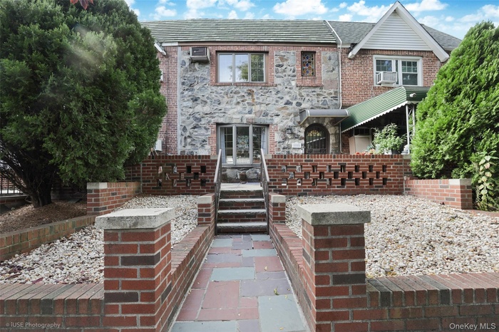 View of front of house with brick siding and a patio area