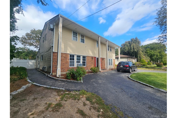 View of front of property with brick siding and asphalt driveway
