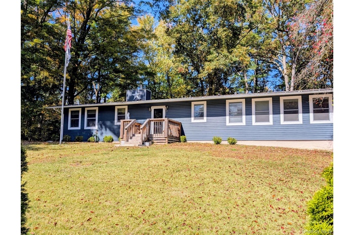 Single story home featuring a front yard and a chimney