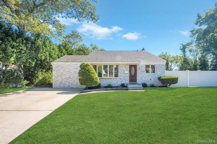 View of front of house featuring a front yard, a shingled roof, and brick siding