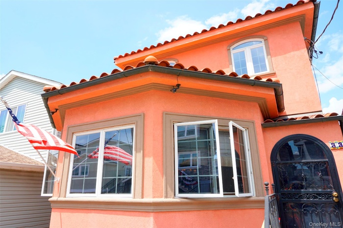 View of property exterior with a tile roof and stucco siding