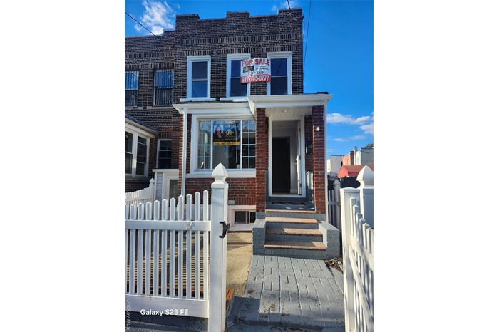 Traditional home with a fenced front yard, brick siding, and a gate