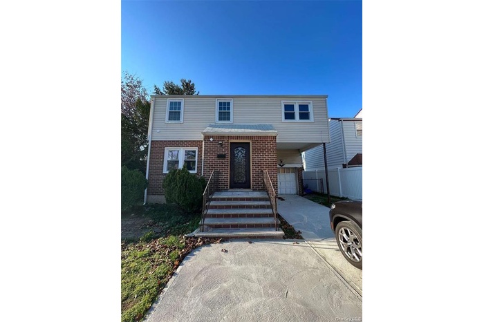 View of front of house with an attached garage, brick siding, and concrete driveway