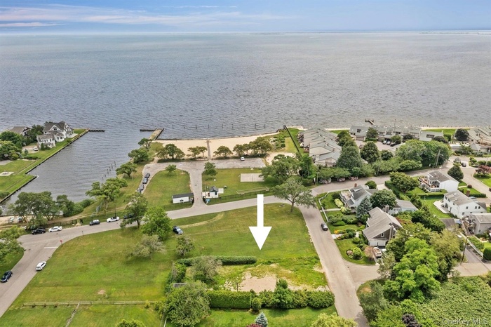 Aerial view of property's location featuring a nearby body of water and nearby suburban area