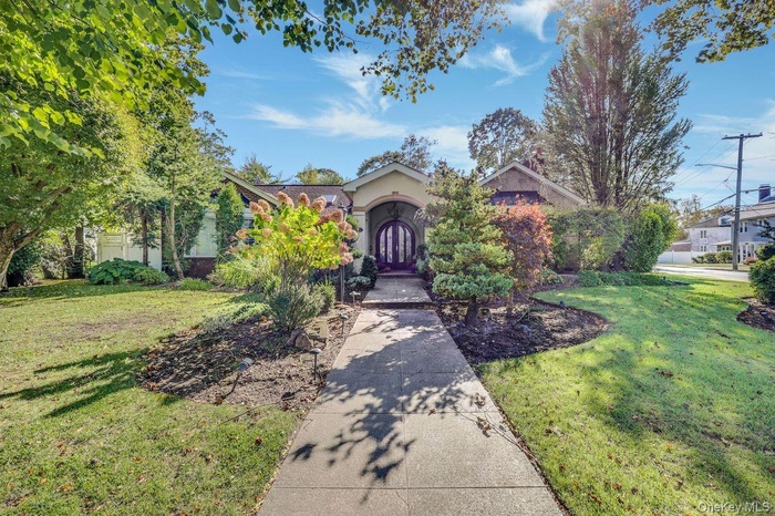 Obstructed view of property featuring a front lawn and stucco siding