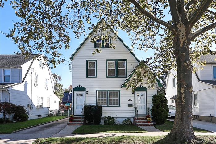 View of front facade with entry steps and a front yard