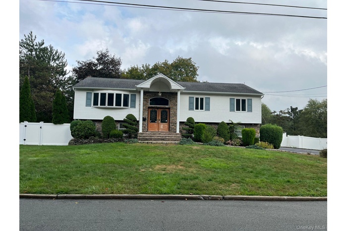 Raised ranch featuring a gate and stone siding