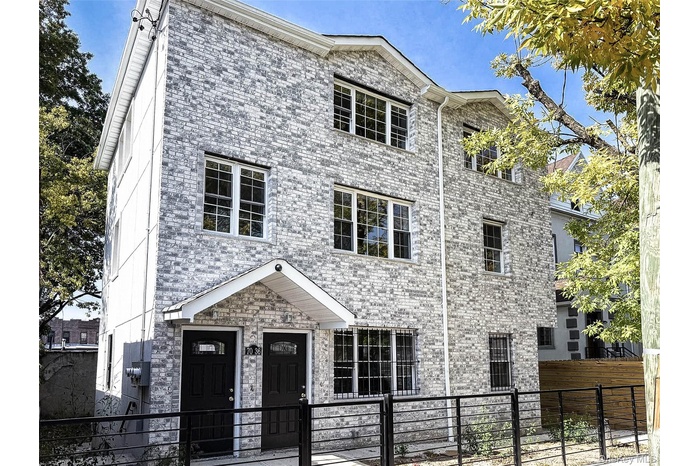 View of front facade with a fenced front yard and brick siding