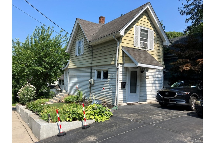 View of home's exterior with a chimney and roof with shingles