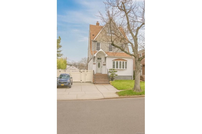 View of front of house with a chimney, a gate, stucco siding, and a shingled roof