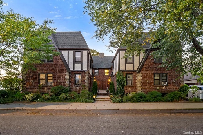 Tudor-style house featuring brick siding and a chimney