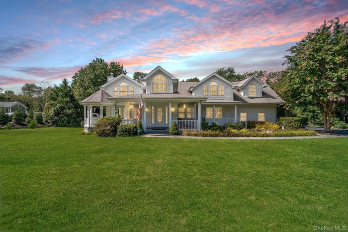 View of front of property with covered porch, a yard, and a chimney