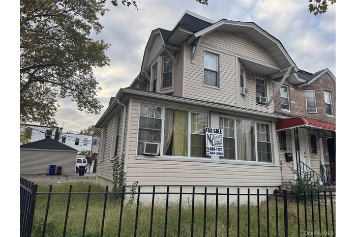 View of side of home with a fenced front yard and cooling unit