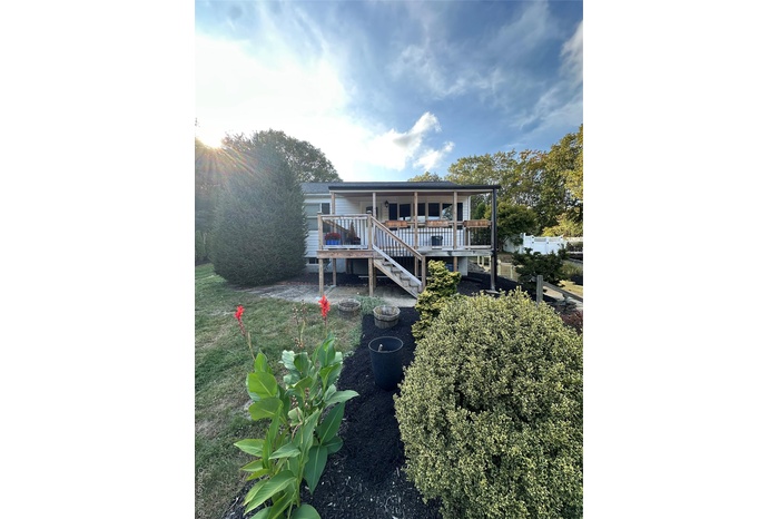View of front of house featuring a wooden deck and stairs