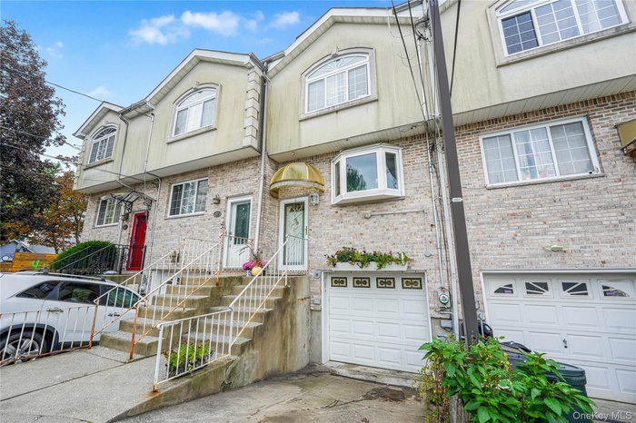 View of front facade featuring brick siding and a garage
