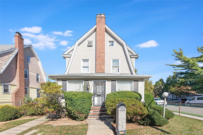Colonial inspired home featuring a gambrel roof and a front yard